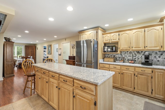 2680 Cedar Grove Rd, Lebanon, TN 37087 - kitchen with freestanding refrigerator, black microwave, light brown cabinets, light stone countertops, and decorative backsplash