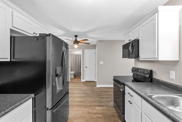 1615 Mohawk Trl, Hopkinsville, KY 42240 - kitchen with black appliances, ceiling fan, dark countertops, white cabinetry, and light wood-style floors
