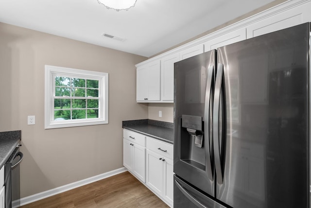 1615 Mohawk Trl, Hopkinsville, KY 42240 - kitchen featuring stainless steel appliances, dark countertops, wood finished floors, and white cabinetry