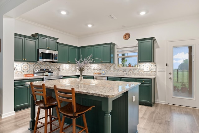 611 Hawkeye Ct, Eagleville, TN 37060 - kitchen with appliances with stainless steel finishes, green cabinetry, light wood-style floors, ornamental molding, and recessed lighting