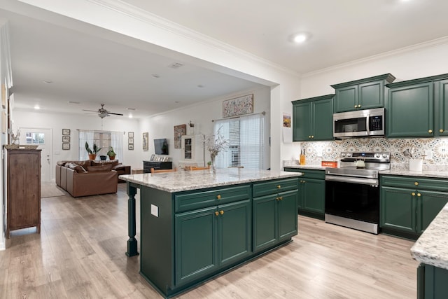 611 Hawkeye Ct, Eagleville, TN 37060 - kitchen with appliances with stainless steel finishes, green cabinetry, light wood-style floors, decorative backsplash, and ornamental molding