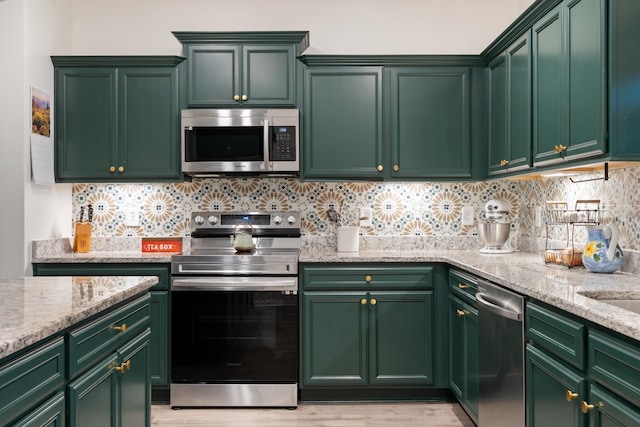 611 Hawkeye Ct, Eagleville, TN 37060 - kitchen featuring appliances with stainless steel finishes, light stone countertops, tasteful backsplash, and light wood finished floors
