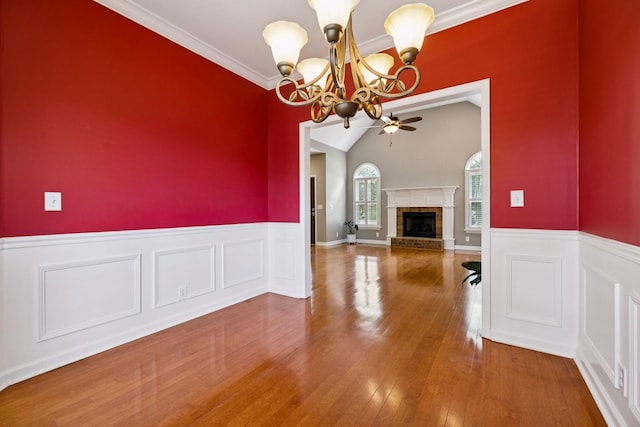 2707 Albany Ct, Murfreesboro, TN 37129 - unfurnished dining area with a chandelier, a wainscoted wall, wood finished floors, a fireplace, and ceiling fan