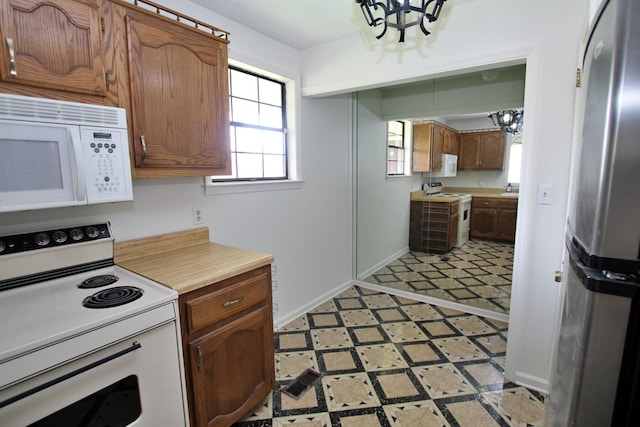 2117 Mockingbird Ln Unit A, Springfield, TN 37172 - kitchen with white appliances, a chandelier, light countertops, light flooring, and brown cabinets