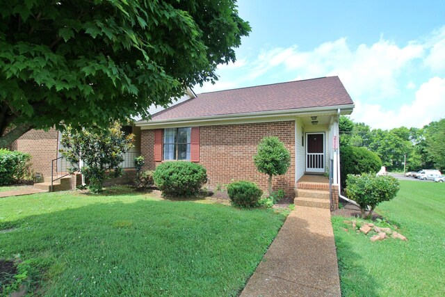 2117 Mockingbird Ln Unit A, Springfield, TN 37172 - view of front facade with brick siding, a front yard, and roof with shingles