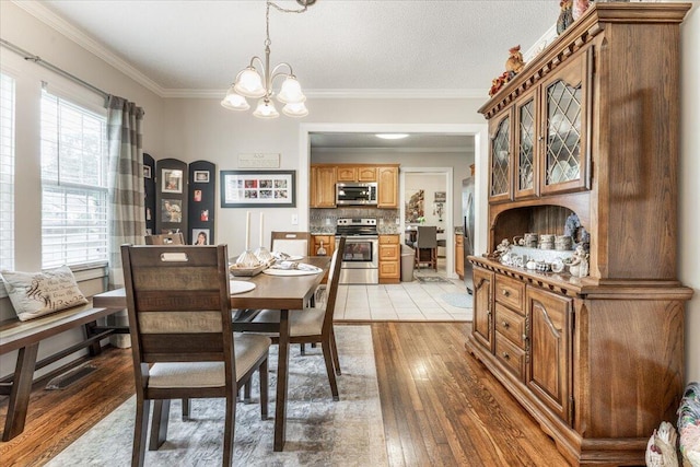 615 S Moore Rd, Chattanooga, TN 37412 - dining room with light wood-style flooring, a chandelier, and crown molding