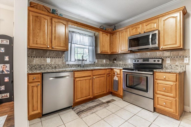 615 S Moore Rd, Chattanooga, TN 37412 - kitchen featuring appliances with stainless steel finishes, ornamental molding, light stone counters, decorative backsplash, and light tile patterned floors
