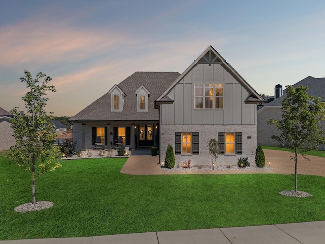 1111 Willow Springs Dr, Lebanon, TN 37087 - back of property at dusk with board and batten siding, a porch, a yard, and brick siding