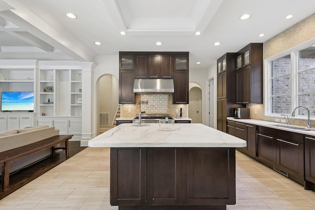 3 Annandale, Nashville, TN 37215 - kitchen featuring under cabinet range hood, recessed lighting, arched walkways, light stone countertops, and backsplash