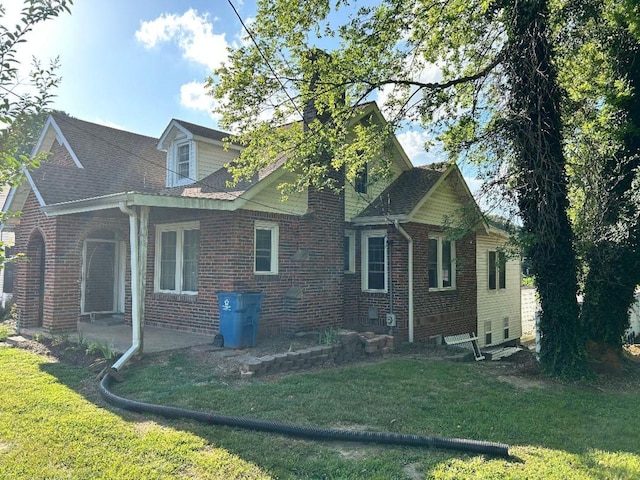 122 W Lake St, Camden, TN 38320 - view of side of home with brick siding, a yard, a patio, and roof with shingles
