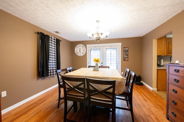 841 Marble Top Rd, Chickamauga, GA 30707 - dining area featuring light wood finished floors, a chandelier, a textured ceiling, and french doors