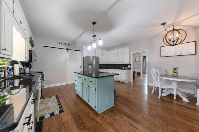 114 Deerview Dr, Columbia, TN 38401 - kitchen with a barn door, stainless steel fridge with ice dispenser, white cabinetry, dark countertops, and a kitchen island