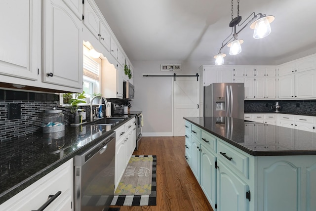 114 Deerview Dr, Columbia, TN 38401 - kitchen featuring appliances with stainless steel finishes, backsplash, dark wood-style flooring, and a barn door