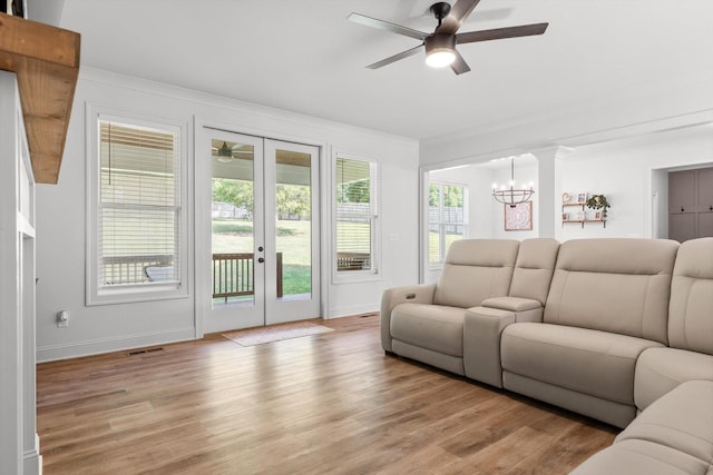 8665 Woodbury Acre Ct, Harrison, TN 37341 - living room featuring french doors, a ceiling fan, light wood-style floors, ornamental molding, and a chandelier