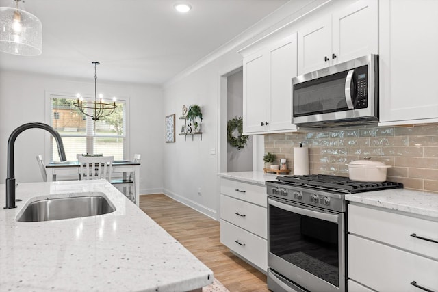 8665 Woodbury Acre Ct, Harrison, TN 37341 - kitchen featuring stainless steel appliances, backsplash, light wood-style floors, crown molding, and white cabinetry