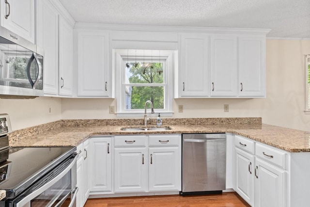 435 Forest St, Lewisburg, TN 37091 - kitchen with appliances with stainless steel finishes, white cabinets, light wood-type flooring, a textured ceiling, and light stone countertops