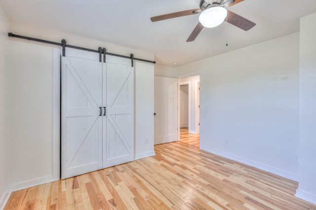 1059 S Cross Bridges Rd, Mount Pleasant, TN 38474 - unfurnished bedroom with wood finished floors, a barn door, and ceiling fan