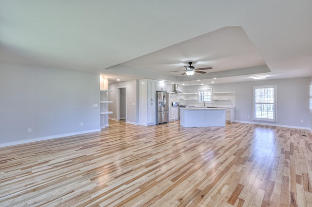 1059 S Cross Bridges Rd, Mount Pleasant, TN 38474 - unfurnished living room with a tray ceiling, light wood-style flooring, and ceiling fan