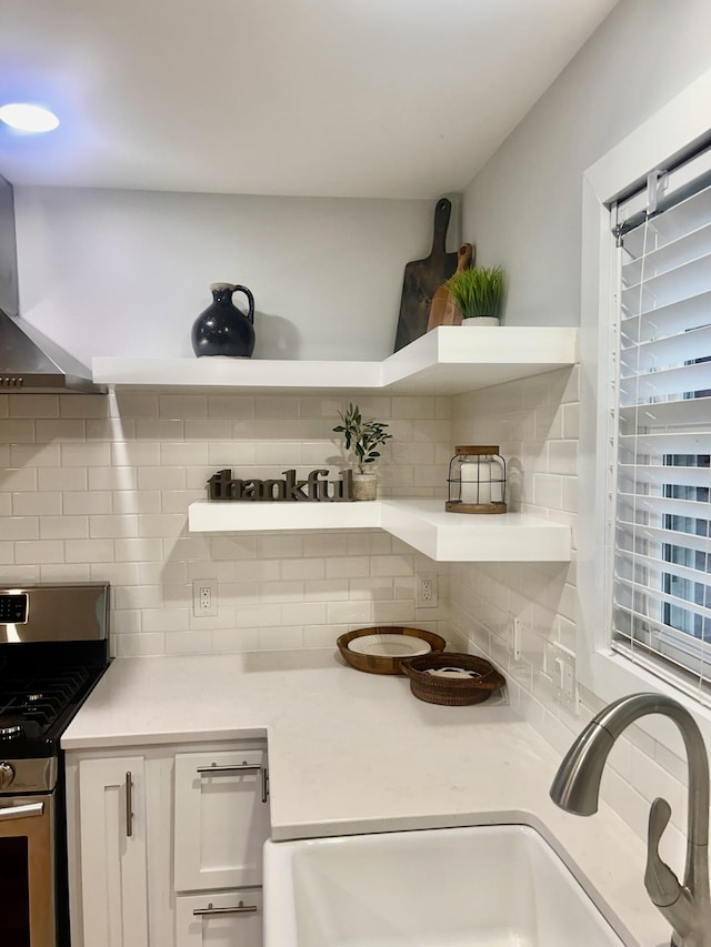 1059 S Cross Bridges Rd, Mount Pleasant, TN 38474 - kitchen view of open shelves, gas stove, backsplash, white cabinetry, and premium range hood