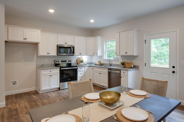 766 Billy Wynn Rd, Dickson, TN 37055 - kitchen featuring appliances with stainless steel finishes, white cabinets, light wood-type flooring, recessed lighting, and light stone countertops