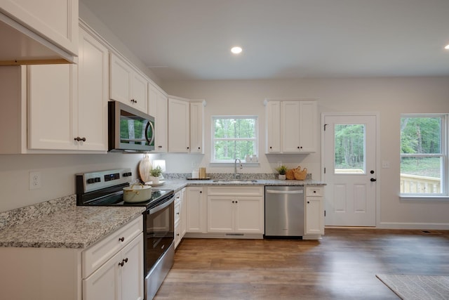 766 Billy Wynn Rd, Dickson, TN 37055 - kitchen featuring stainless steel appliances, light wood finished floors, recessed lighting, white cabinets, and light stone counters