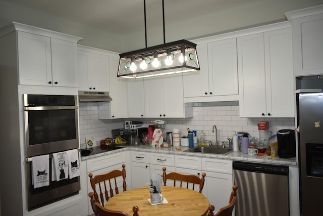 704 Main St N, Carthage, TN 37030 - kitchen with stainless steel appliances, under cabinet range hood, white cabinetry, and backsplash
