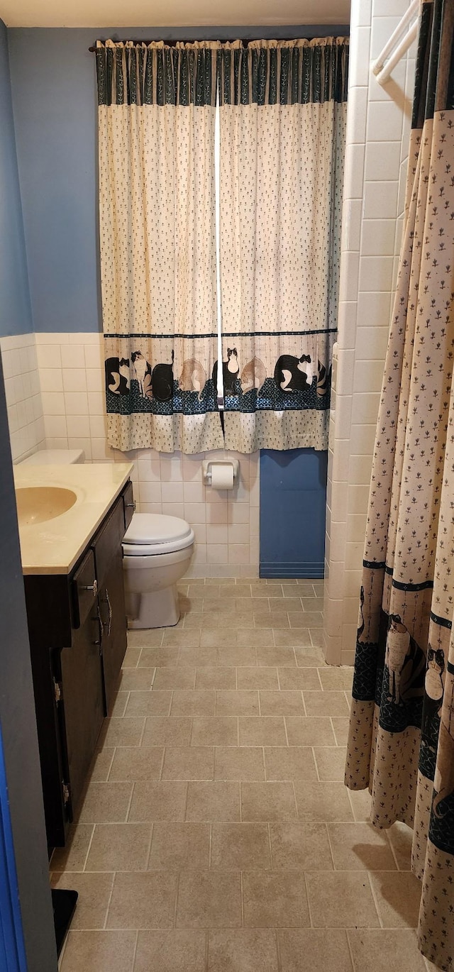704 Main St N, Carthage, TN 37030 - full bath featuring tile walls, vanity, a shower with shower curtain, and wainscoting