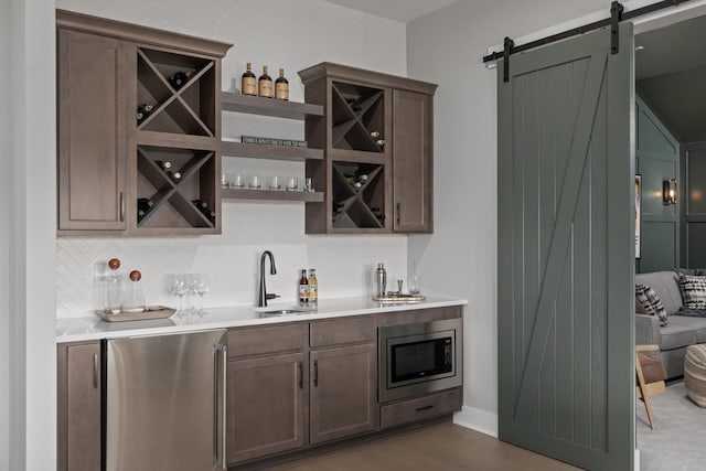 7103A Kyles Creek Dr, Fairview, TN 37062 - indoor wet bar featuring appliances with stainless steel finishes, a barn door, and tasteful backsplash