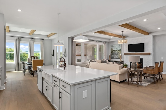 7103A Kyles Creek Dr, Fairview, TN 37062 - kitchen featuring light wood finished floors, stainless steel dishwasher, beam ceiling, light countertops, and a kitchen island with sink