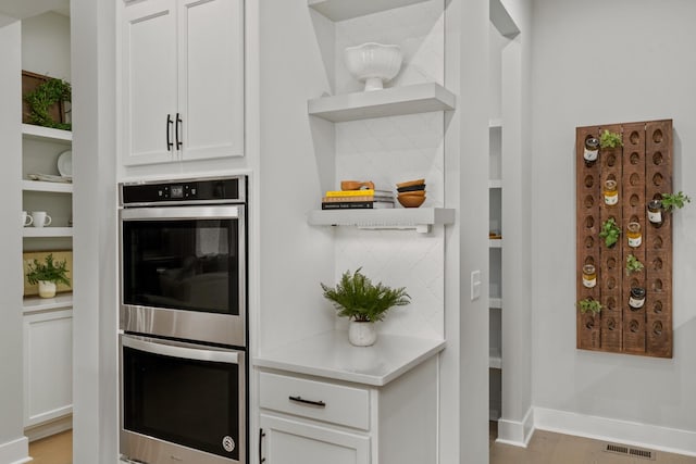 7103A Kyles Creek Dr, Fairview, TN 37062 - kitchen with open shelves, stainless steel double oven, white cabinetry, light countertops, and built in shelves
