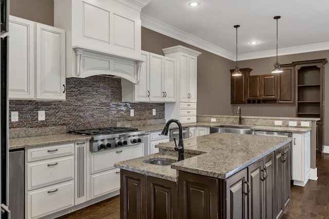 3699 Sweethome Rd, Ashland City, TN 37015 - kitchen with stainless steel gas stovetop, a kitchen island with sink, a peninsula, white cabinets, and crown molding