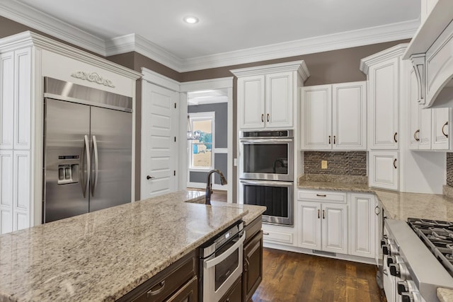 3699 Sweethome Rd, Ashland City, TN 37015 - kitchen with appliances with stainless steel finishes, white cabinets, light stone countertops, backsplash, and crown molding