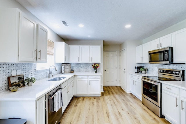 1018 Lowrey Pl, Spring Hill, TN 37174 - kitchen with appliances with stainless steel finishes, decorative backsplash, white cabinetry, light countertops, and recessed lighting