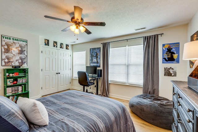 1018 Lowrey Pl, Spring Hill, TN 37174 - bedroom with light wood-style flooring, a textured ceiling, a ceiling fan, and a closet