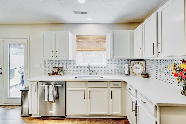 1018 Lowrey Pl, Spring Hill, TN 37174 - kitchen featuring stainless steel dishwasher, light countertops, decorative backsplash, wood finished floors, and a textured ceiling