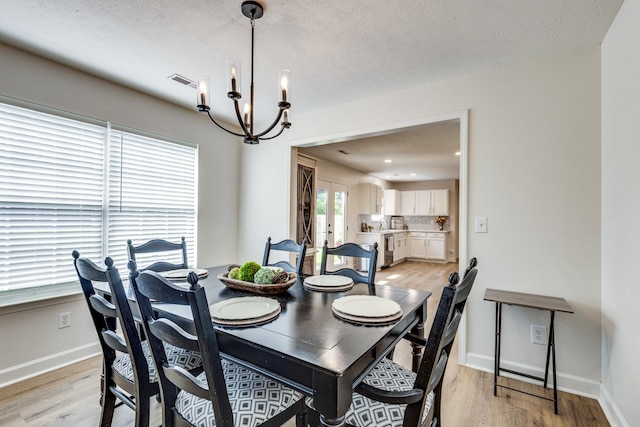 1018 Lowrey Pl, Spring Hill, TN 37174 - dining area with a chandelier, light wood-style flooring, french doors, and a textured ceiling