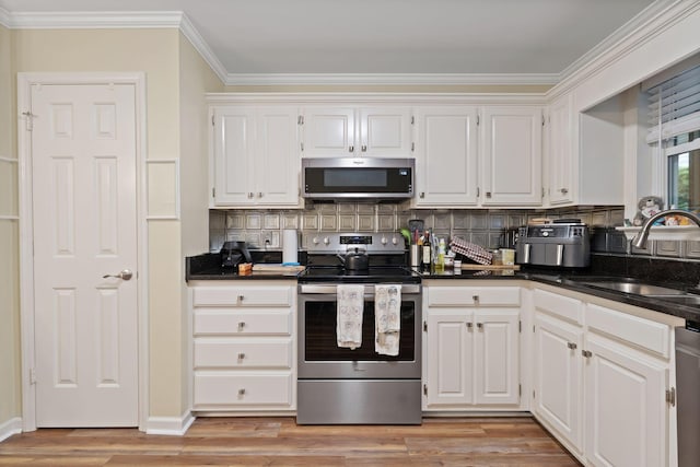 1438 Anita Ct, Murfreesboro, TN 37130 - kitchen with stainless steel appliances, dark countertops, crown molding, tasteful backsplash, and white cabinets