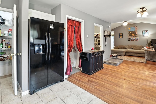 206 Cross Valley Dr, Columbia, TN 38401 - kitchen with black fridge with ice dispenser, white cabinets, light tile patterned floors, and vaulted ceiling