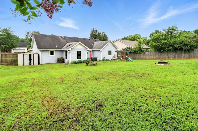 206 Cross Valley Dr, Columbia, TN 38401 - rear view of house with a playground, a fire pit, a storage unit, and a fenced backyard