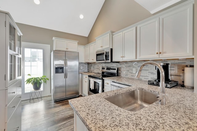 3424 Learning Ln, Murfreesboro, TN 37128 - kitchen with stainless steel appliances, white cabinetry, light stone counters, tasteful backsplash, and vaulted ceiling