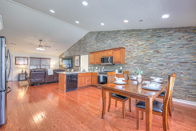 1005 Lark Ct, Spring Hill, TN 37174 - kitchen with appliances with stainless steel finishes, a peninsula, open floor plan, light wood-style flooring, and brown cabinets