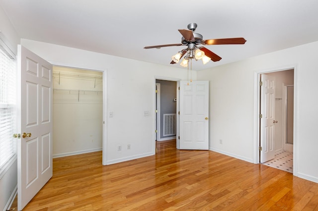 381 Bailey Ln, Pleasant View, TN 37146 - unfurnished bedroom with light wood finished floors, a spacious closet, a ceiling fan, and ensuite bathroom