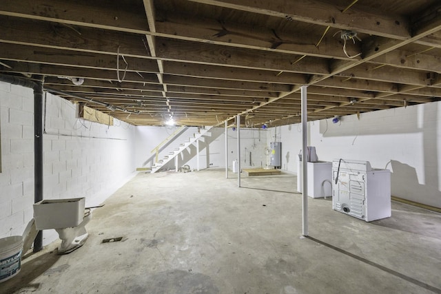 55 Lancaster Ln, Parsons, TN 38363 - unfinished below grade area with tankless water heater, washer / dryer, stairs, and concrete block wall