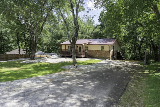 55 Lancaster Ln, Parsons, TN 38363 - ranch-style house featuring a deck, stone siding, driveway, and a metal roof