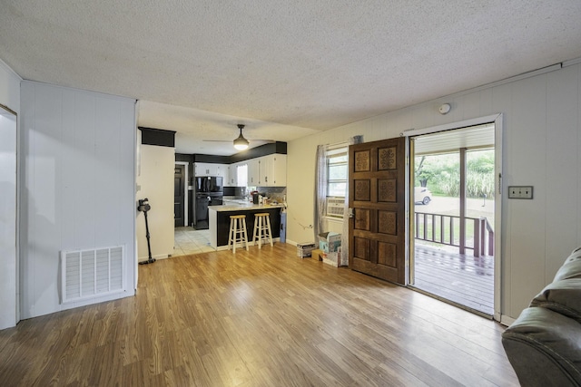 55 Lancaster Ln, Parsons, TN 38363 - living room with light wood finished floors, a textured ceiling, and a ceiling fan