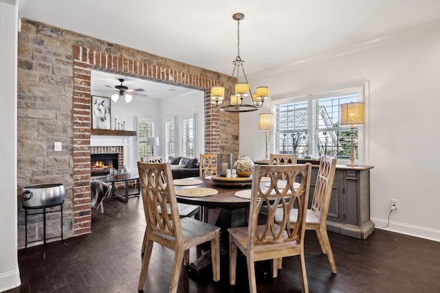 4376 Pretoria Run, Murfreesboro, TN 37128 - dining area with a ceiling fan, dark wood-style floors, a fireplace, a chandelier, and crown molding