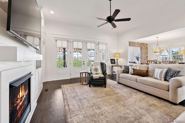 4376 Pretoria Run, Murfreesboro, TN 37128 - living area featuring dark wood finished floors, ceiling fan, a chandelier, a warm lit fireplace, and recessed lighting
