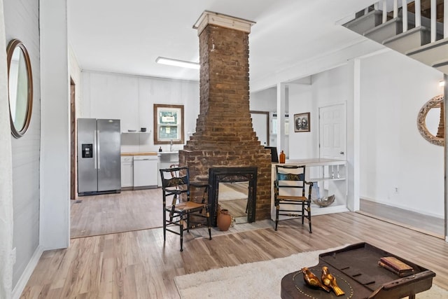 584 Limestone Ave, Lewisburg, TN 37091 - living area featuring light wood-type flooring, a brick fireplace, and decorative columns