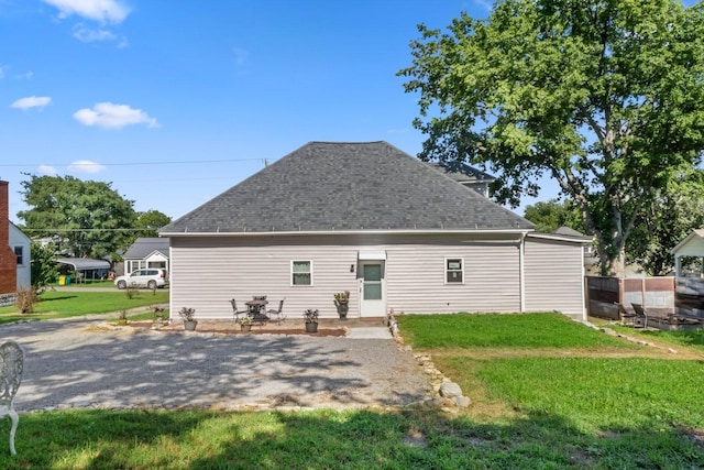 584 Limestone Ave, Lewisburg, TN 37091 - back of property with a shingled roof, a lawn, and a patio area
