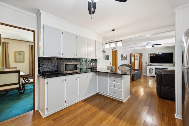 1148 Green Valley Dr, Lewisburg, TN 37091 - kitchen with ceiling fan, appliances with stainless steel finishes, dark countertops, open floor plan, and crown molding